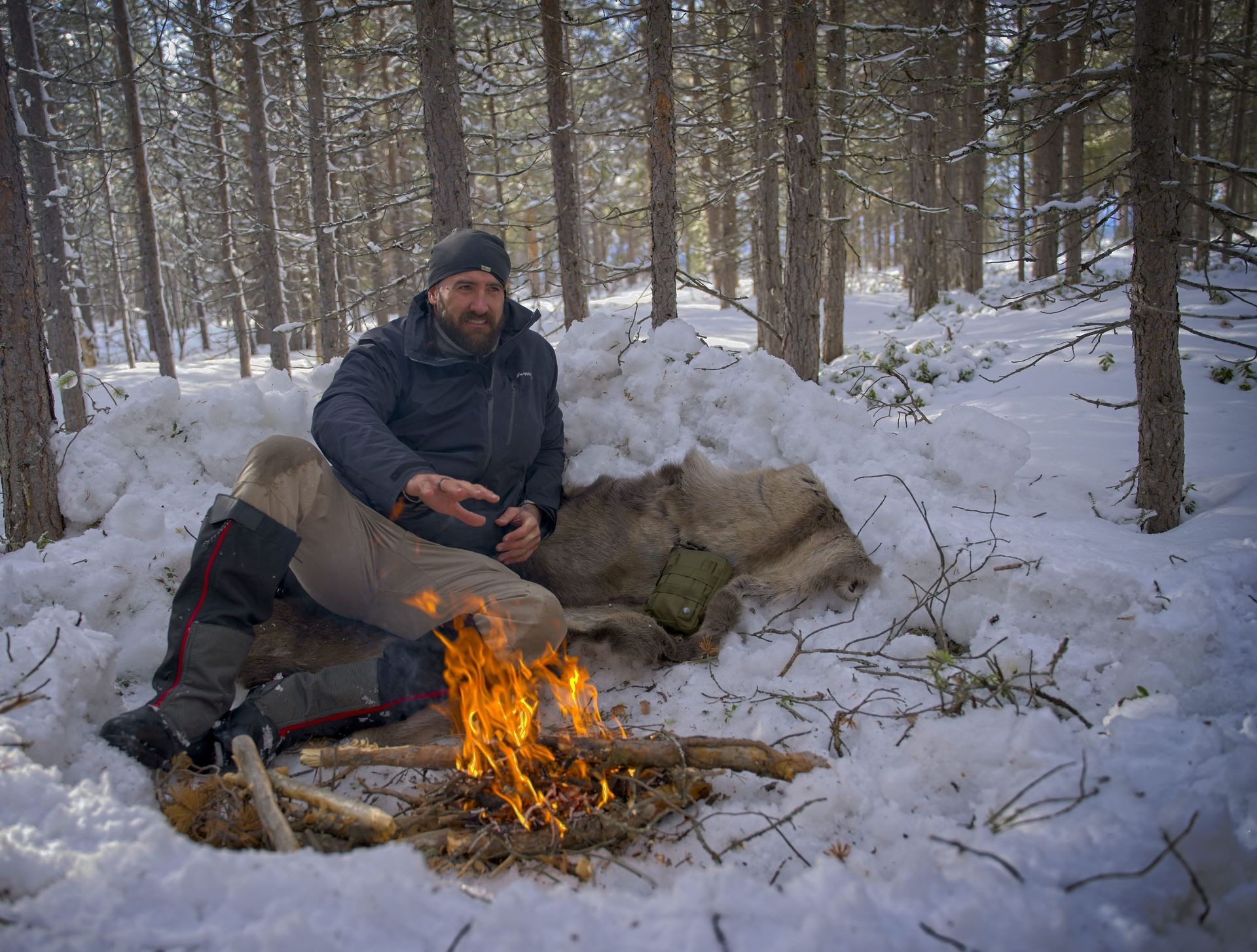 Men next to fire in a snow covered forest